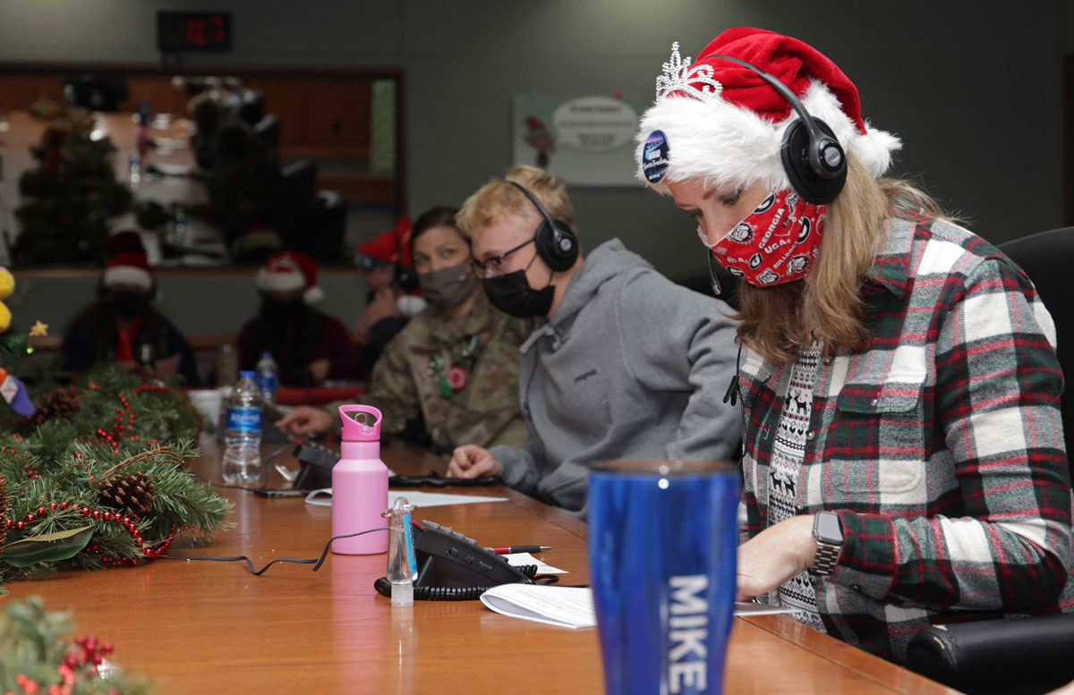Volunteers answer phones and emails from children around the world during the NORAD Tracks Santa event at Peterson Air Force Base. Photo by Jhomil Bansil