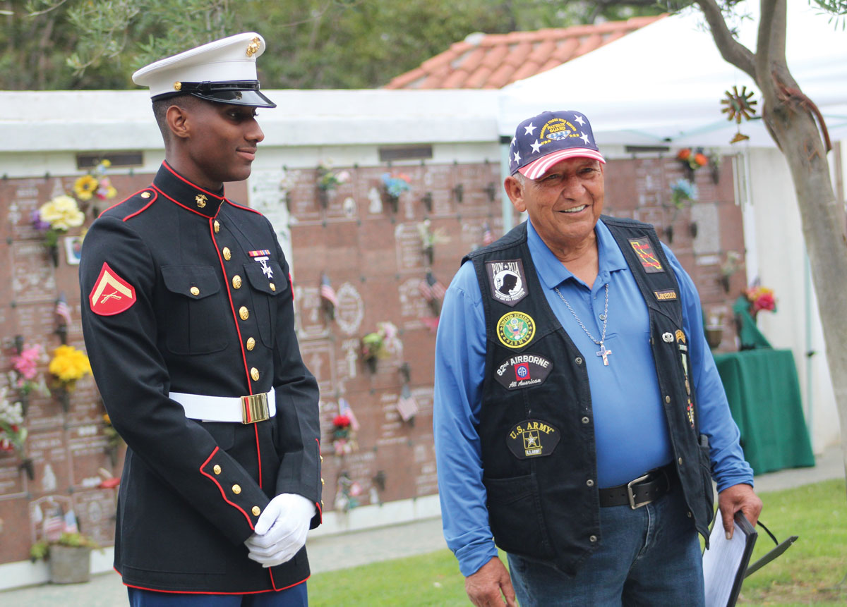 army veteran Lorenzo Lizarraga, right, speaks with an active-duty Marine during a funeral ceremony celebrating the military career and life of 1st Sgt. Herbert Olayvar at Old Mission San Luis Rey Cemetery in Oceanside. Photo by Jordan P. Ingram