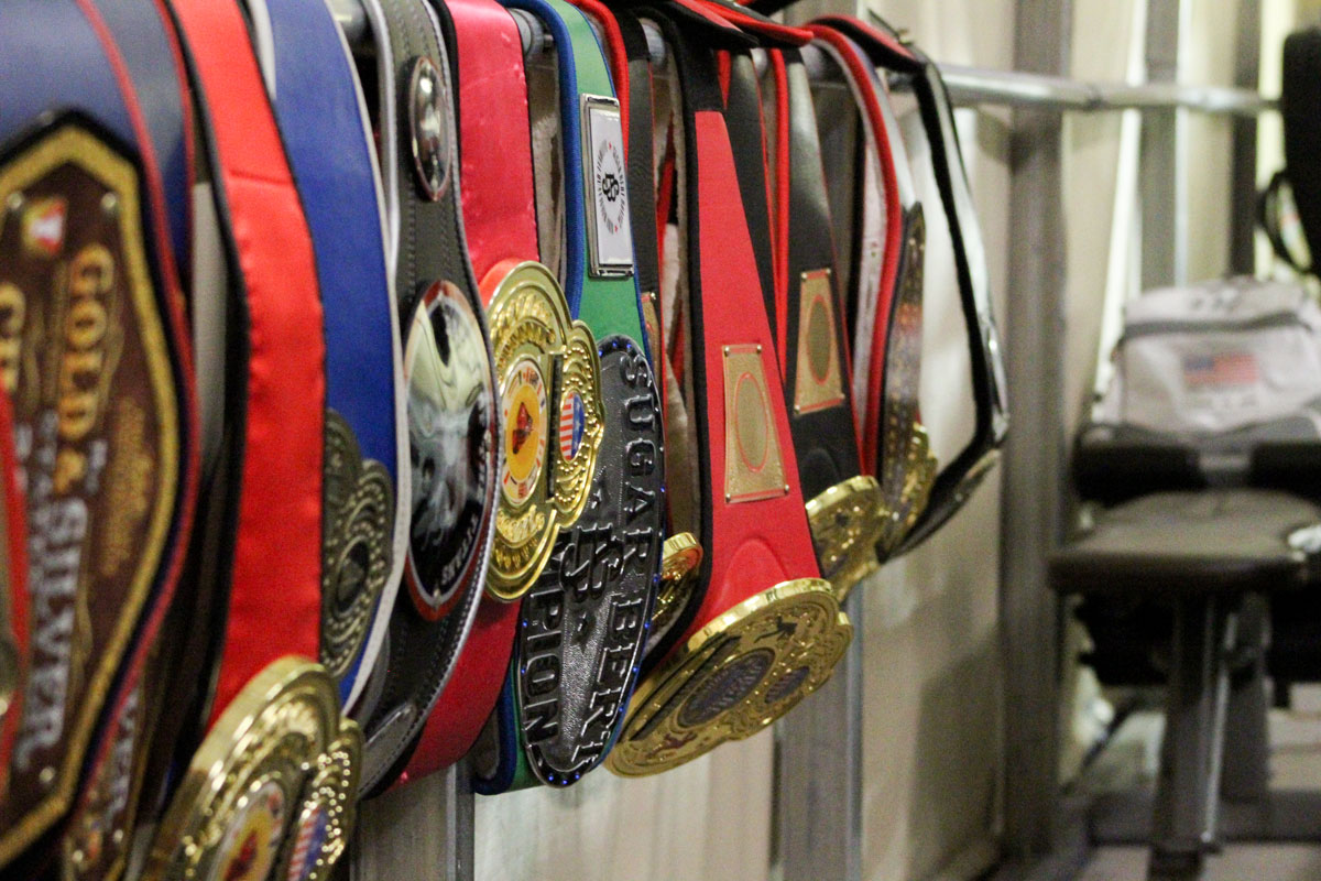 Championship belts hang on the wall at the Vista Boxing Club. Photo by Steve Puterski