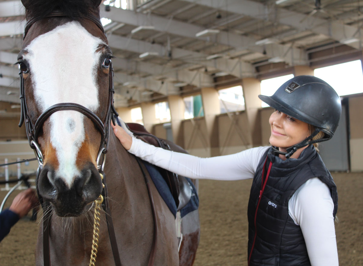 Francie Nilforushan pats her equestrian partner Valentino, a Dutch warmblood imported from Holland, during a Jan. 15 practice in preparation for the Seaside Equestrian Tour at Del Mar Arena. Photo by Jordan P. Ingram