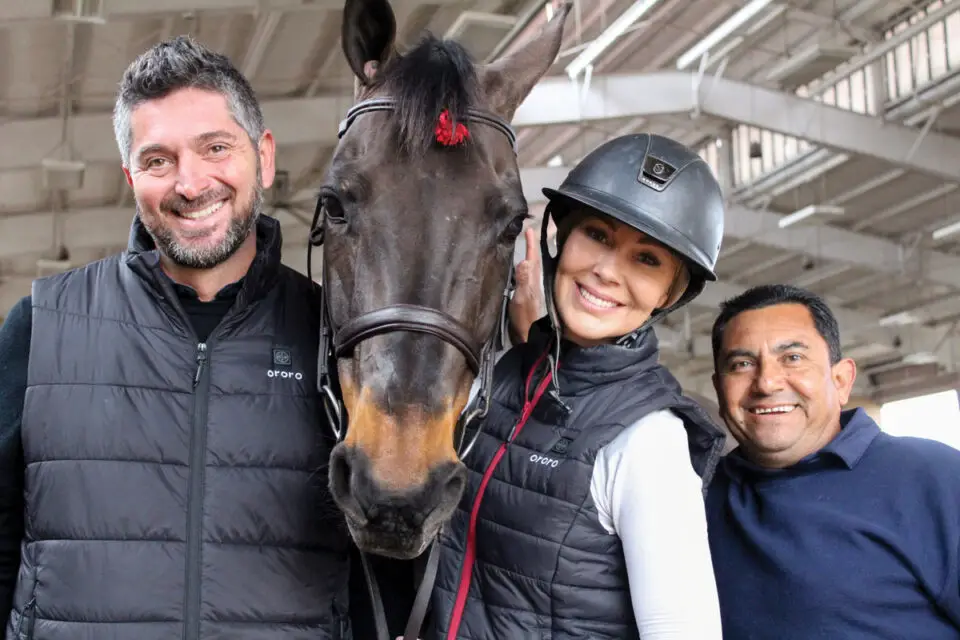 Ali Nilforushan, left, and his wife Francie, owners of Nilforushan Equisports Events, with Dutch warmblood Valentino and trainer Emilio at an equestrian training facility on Jan. 15 at the Del Mar Fairgrounds. Photo by Jordan P. Ingram