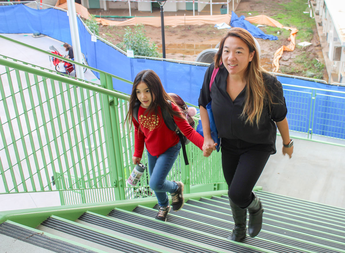 A student and her mother head to her classroom on the new Richland Elementary School campus in San Marcos on Monday, with the old campus visible in the background. Photo by Laura Place