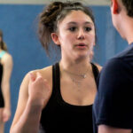 Jill Lastra, left, speaks with a gymnastics coach at a recent practice at Coastal Gymnastics Academy in Vista. Lastra broke her back two years ago, but has recovered and will compete at Sacramento State next year. Photo by Steve Puterski