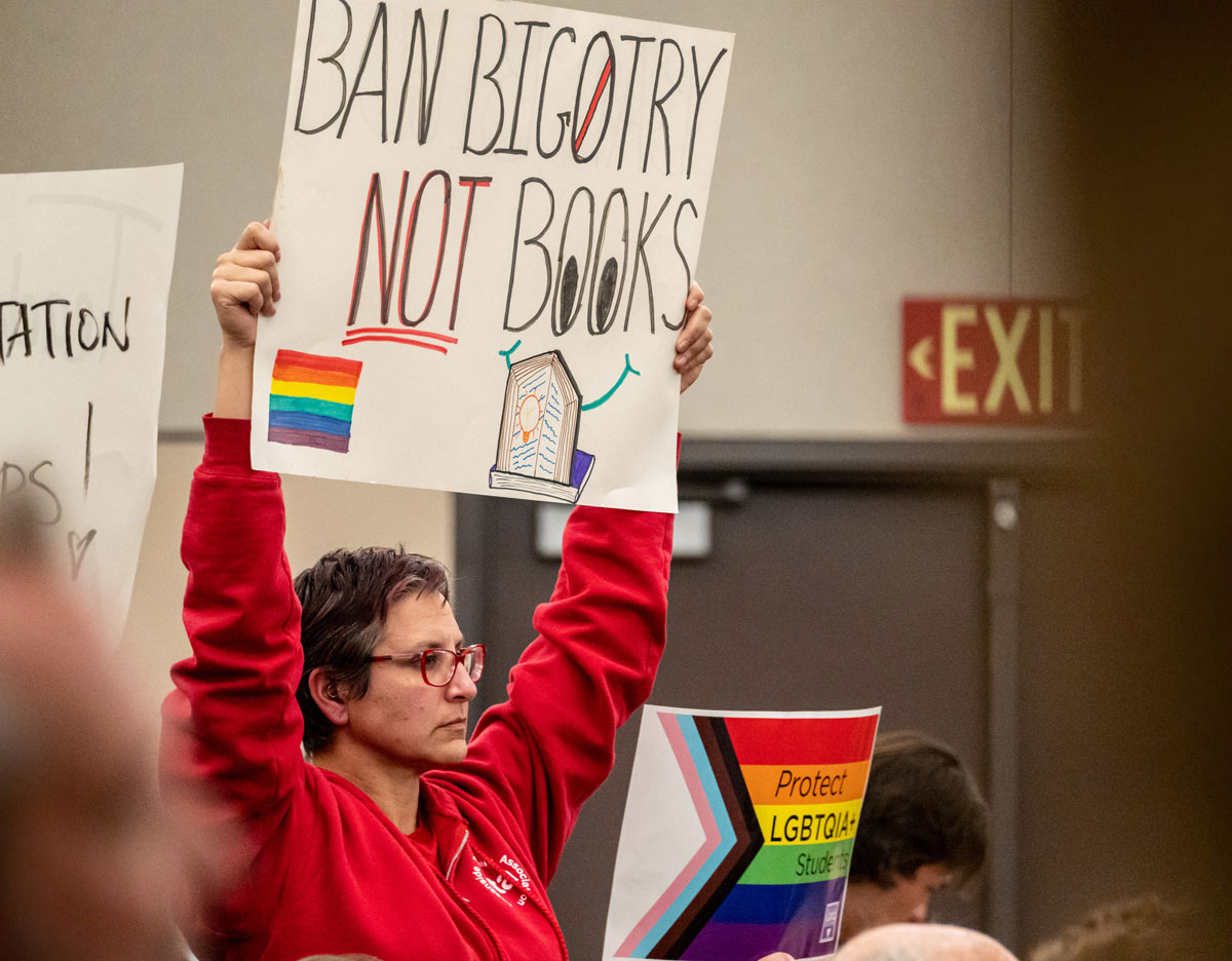 A woman holds up a sign in opposition to a proposal to ban books with LGBTQ themes during the Oceanside Unified School District's Feb. 7 board meeting. Photo by Joe Orellana