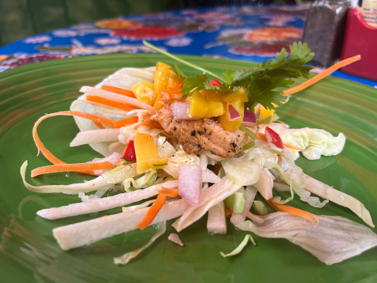 Spicy Salmon Tacos feature grilled wild salmon served inside two fresh lettuce leaves, topped with jicama slaw, shredded cabbage, and habanero and chipotle mango salsa. Photo by Jordan P. Ingram