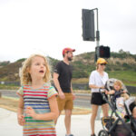 Stella Staub and her family wait to cross Manchester Avenue from the San Elijo Activity Hub Park and Ride in Cardiff to go on a morning hike on Aug. 12. Photo by Laura Place