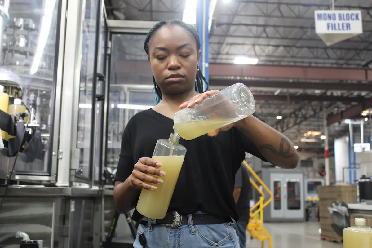 Lead Production Operator Kyana Moore completes quality control tests for Dr. Bronner’s liquid soap at the company factory in Vista. Photo by Laura Place