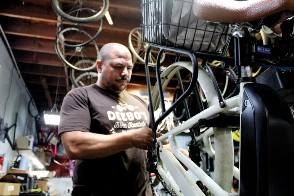 Kanyama Sharpe, head tech at Leucadia Cyclery, repairs a bike last November in the shop’s old service bay on Vulcan Avenue. The store has since relocated to 1900 N. Coast Highway 101 in Encinitas. Photo by Jordan P. Ingram