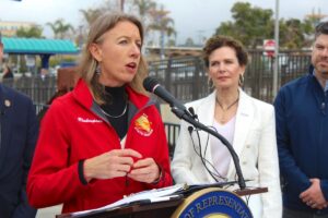 State Sen. Catherine Blakespear describes the importance of a coordinated approach between local and state agencies to address issues with the LOSSAN Rail Corridor during a press conference at the Oceanside Transit Center on Thursday. Photo by Laura Place