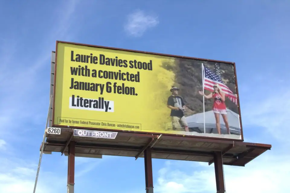 A billboard at South Santa Fe Drive and Terrace Drive in Vista shows a 2020 photo of Assemblywoman Laurie Davies and Alan Hostetter. Hostetter was sentenced to more than 11 years in prison for his role in the Capitol insurrection on Jan. 6, 2021. Photo by Laura Place