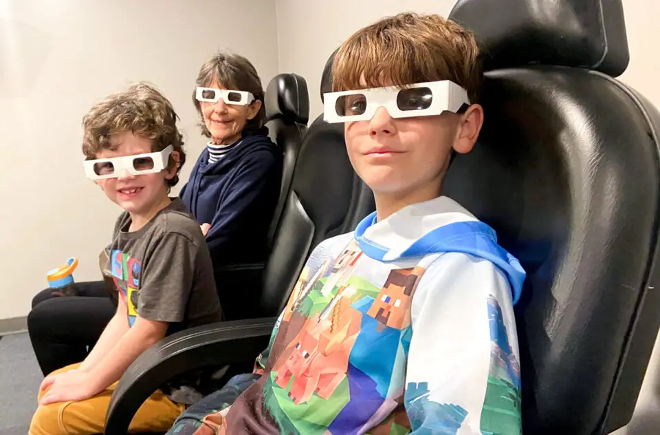 From left: Wolfie Ritter, 6, Shannon Woods of Vista, and Landon Barnhart, 8, of Carlsbad, prepare to see “Legend of Apollo,” a 3D/4D film about the moon landing and exploration of the Apollo 15 mission. Photo by E’Louise Ondash