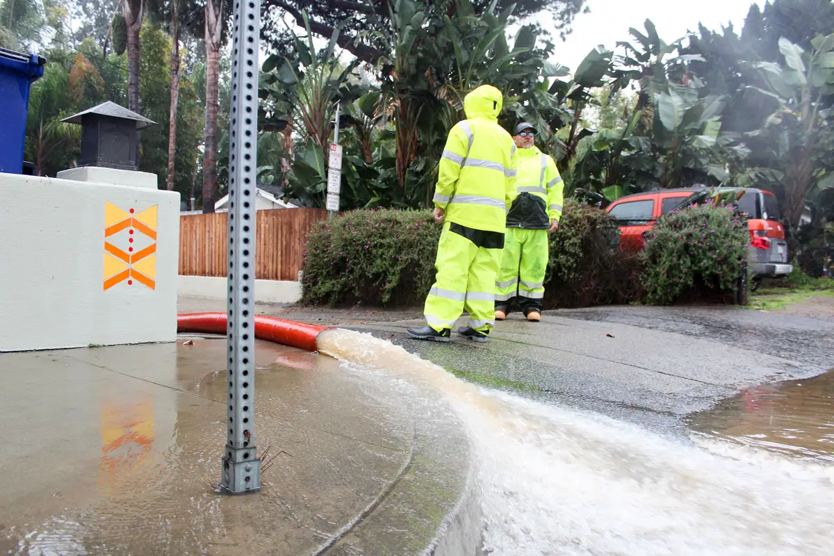 Leucadia flooding: Public works crews monitor water pumps diverting stormwater from the alley to Beacon's Beach. Photo by Jordan P. Ingram