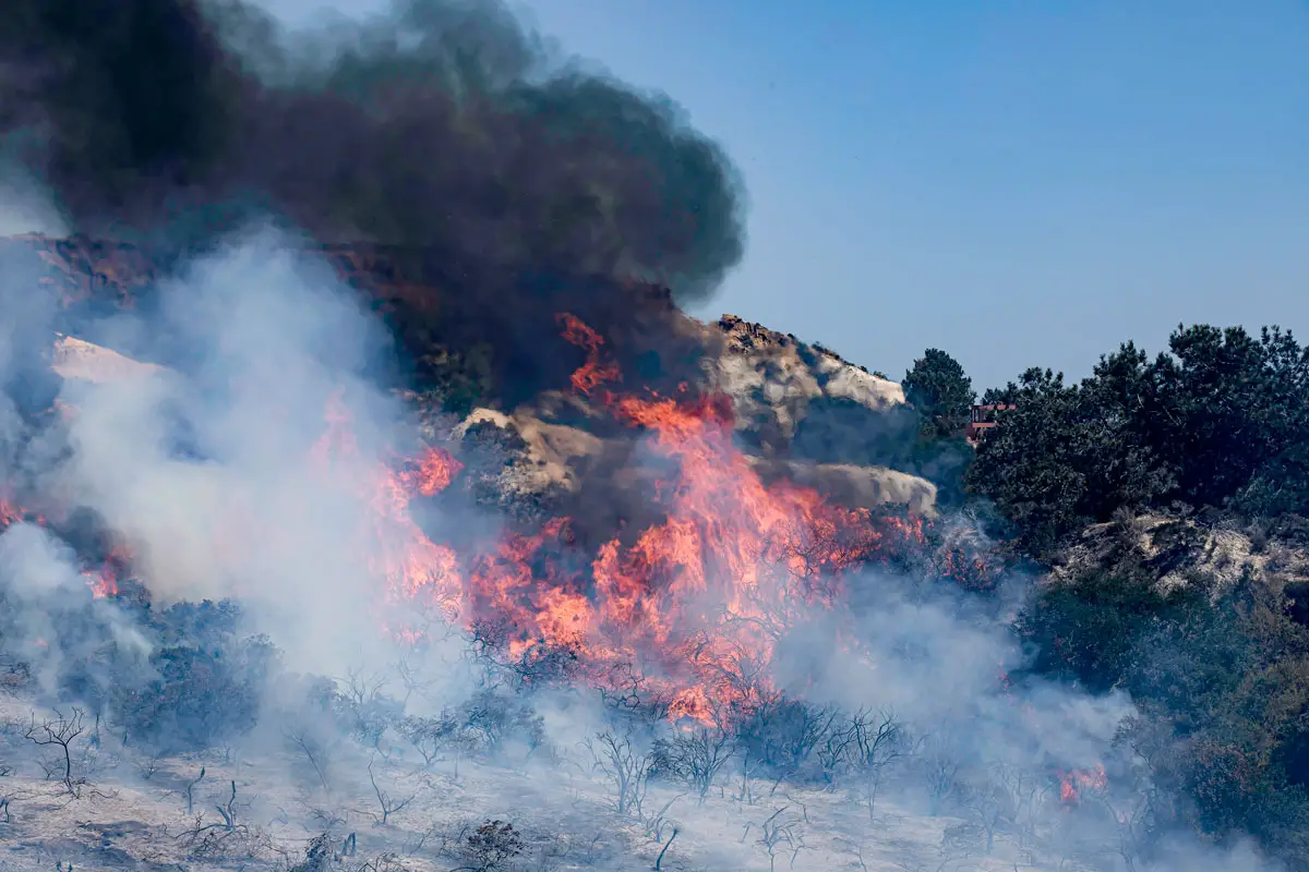 A brush fire reignited on Tuesday afternoon, forcing thousands of residents to evacuate their homes while crews worked to stamp out the blaze. Photo by Ryan Grothe