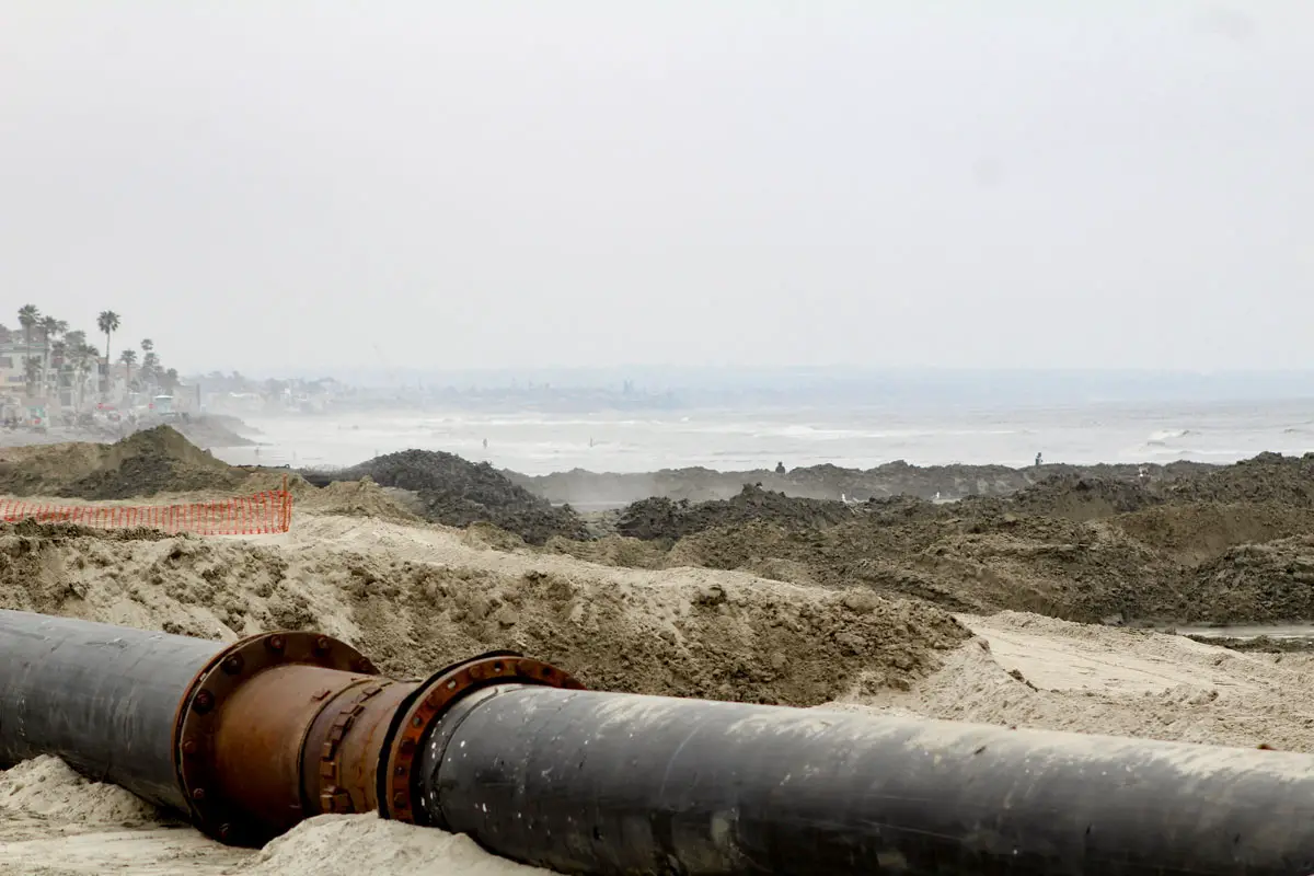 A pipeline pumps sand dredged from the Harbor inlet to beaches immediately south of Oceanside Pier. Photo by Samantha Nelson