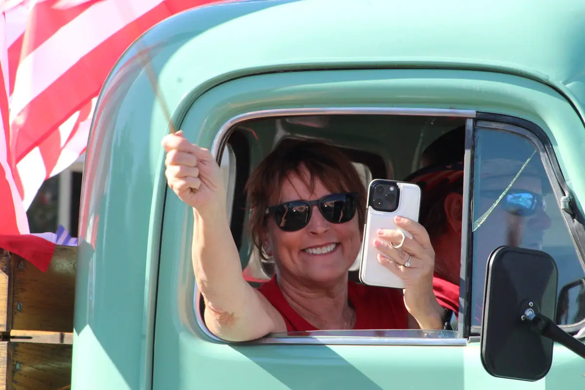 A passenger waves a miniature American flag during a Veterans Day Parade on Nov. 11 in Fallbrook. Photo by Samantha Nelson