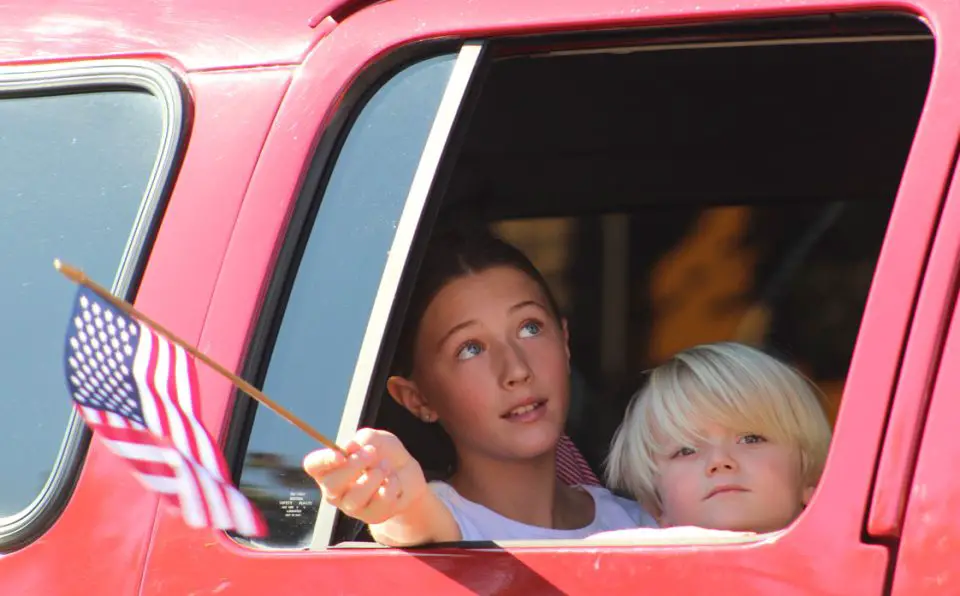 Children wave miniature flags during a Veterans Day parade on Nov. 11 in Fallbrook. Photo by Samantha Nelson