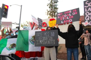 Manifestantes sostienen banderas mexicanas y carteles en respuesta al aumento de la aplicación de la ley por parte de ICE y las deportaciones el 29 de enero en Escondido. Foto por Samantha Nelson.