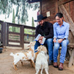 Elizabeth and Bubba Sugarman feed goats on March 31 at the family's Olivenhain farm, Sugar Sweet Farm. Photo by Jordan P. Ingram