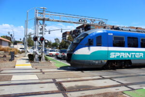 Vehicles wait to cross the rail tracks at Vista Village Drive in Vista on Tuesday as the Sprinter heads toward the Vista Transit Center. Photo by Leo Place