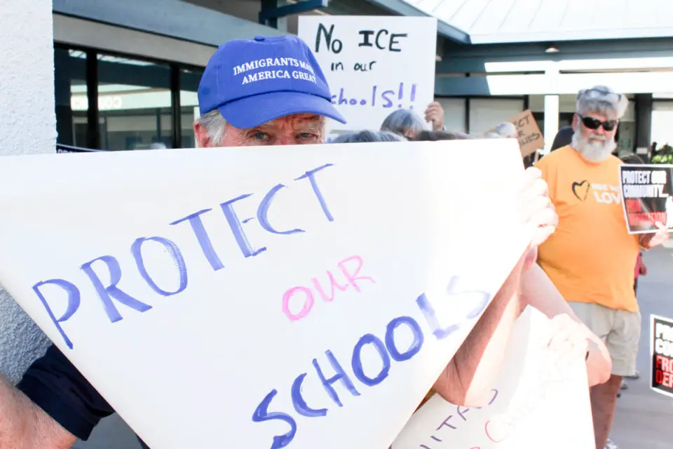 Leucadia resident Ron Ranson holds a sign during an Aug. 20 protest in response to a series of ICE arrests in Encinitas. Photo by Cameron Adams