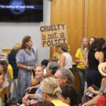 Residents, some holding signs in response to recent ICE arrests in the city, attend an Aug. 20 council meeting. Photo by Cameron Adams