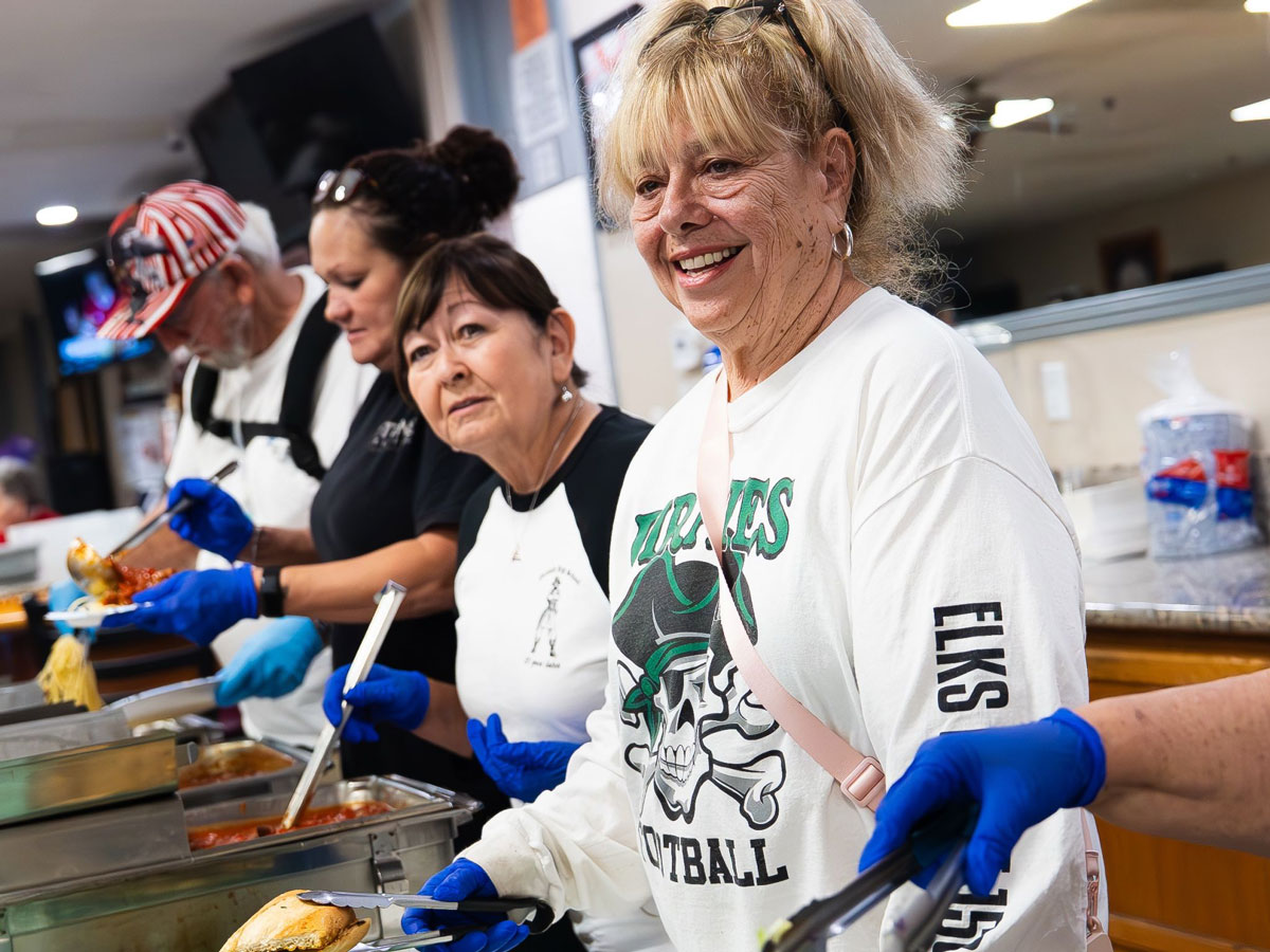 Elks Lodge members serve food to Oceanside High football players during one of the team’s weekly Thursday night dinners. Photo by Nate Tafao