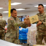 Calfresh: Under the governor's statewide emergency order, California National Guard service members pass food kits for distribution on Oct. 27 in Los Angeles. Photo by Sgt. William Franco Espinosa