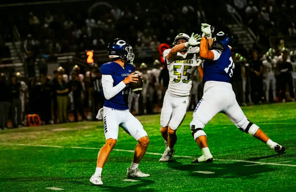 Carlsbad High quarterback scans the field for an open receiver as La Costa Canyon defenders close in during the teams’ crosstown football game.