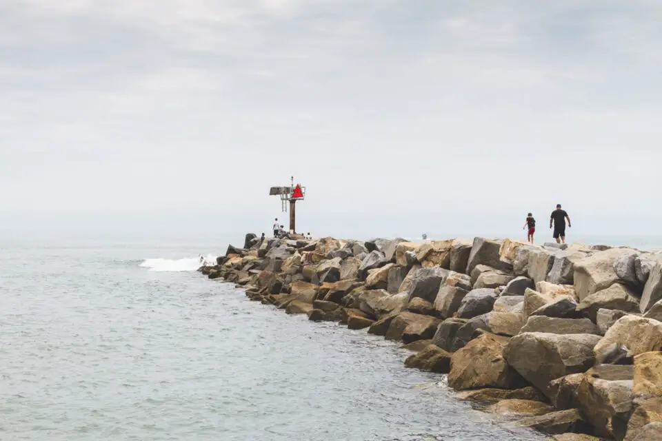 Oceanside fire officials say a 12-year-old junior lifeguard assisted in rescuing five people after a vessel overturned in the surf near the jetty. Photo by Preston Wingrove