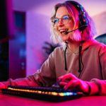 Beautiful young woman playing a video game on her desktop pc at home.