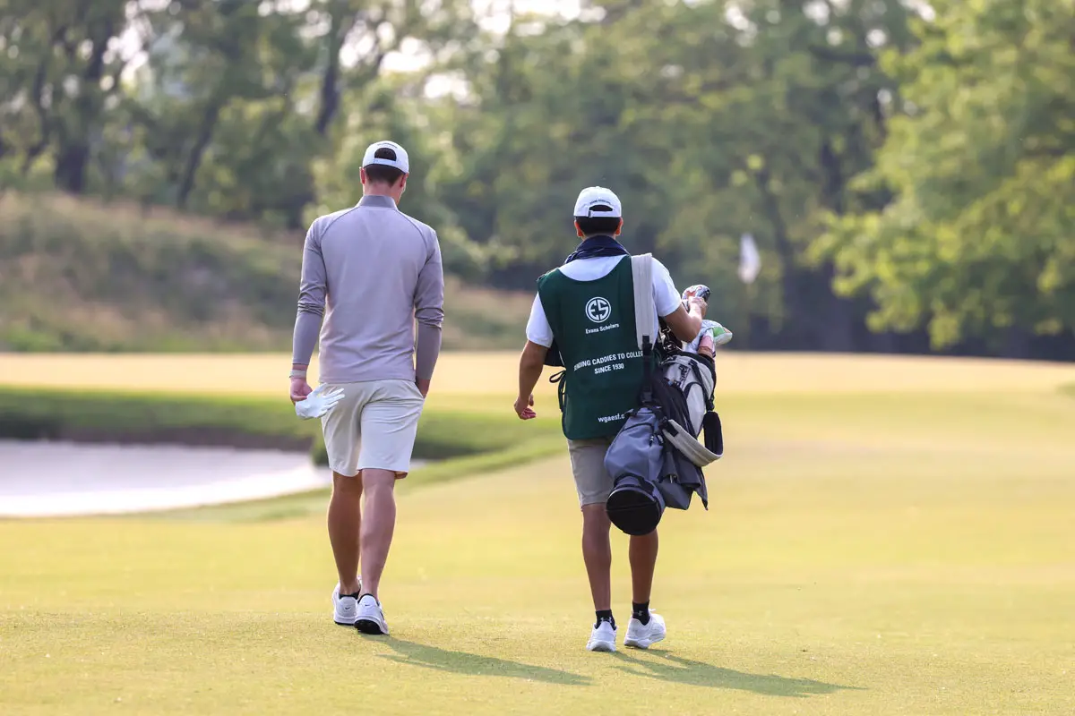 A young caddy carries a golfer's clubs. The Evans Scholars Foundation awards full college scholarships to student caddies who demonstrate strong academics, financial need and character. Courtesy photo