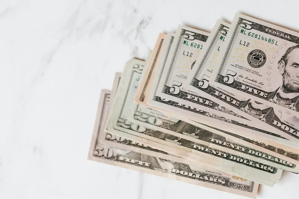Different dollar bills on marble surface