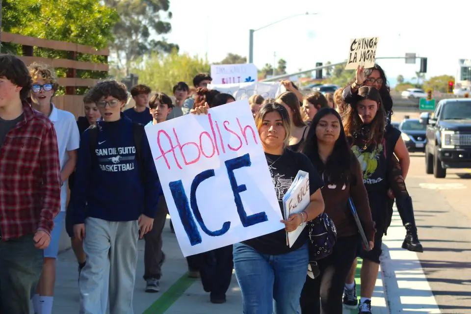Juliet Venegas, center, and hundreds of other San Dieguito Academy students walk along Santa Fe Drive during a campus walkout on Friday to protest Immigration and Customs Enforcement. Photo by Leo Place