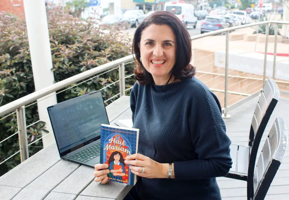 Encinitas author Huda Al-Marashi holds her new book, "Hail Mariam." Photo by Cameron Adams
