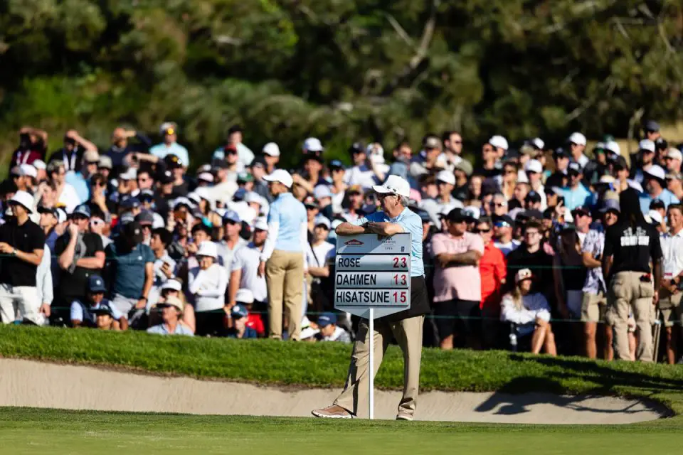 A tournament worker rests his arms on a leaderboard showing Justin Rose atop the field at 23-under par during the Farmers Insurance Open at Torrey Pines Golf Course. Courtesy photo/Farmers Open