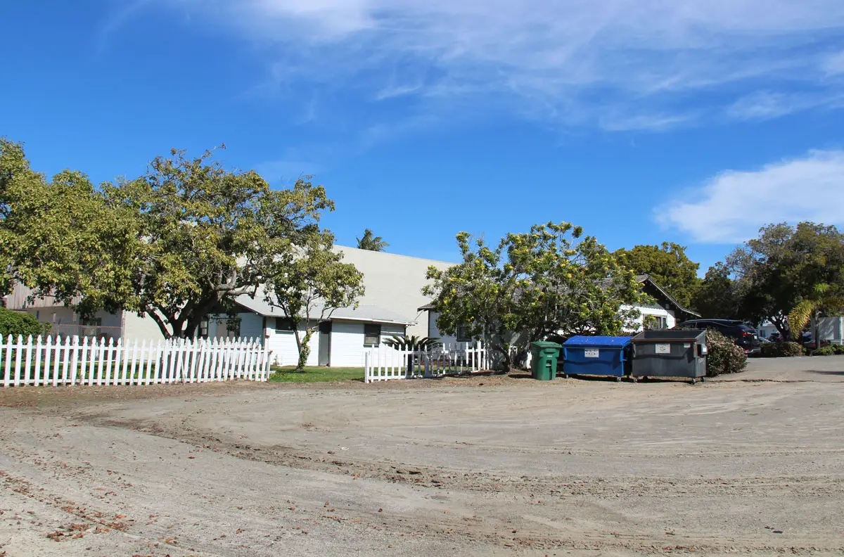 A gravel lot next to existing apartments at the site of the proposed Rincon Roosevelt project in Carlsbad Village. Photo by Jordan P. Ingram