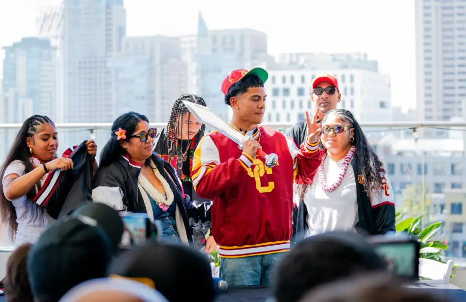 Cathedral Catholic junior Honor Fa’alave-Johnson puts on USC gear after announcing his commitment to the Trojans during a ceremony March 14 at the Andaz San Diego in the Gaslamp Quarter. Photo by Isaac Angel