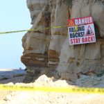 Yellow caution tape and a warning sign mark the scene of a bluff collapse near Dog Beach on Wednesday in Del Mar. Photo by Cameron Adams