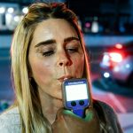 A woman takes part in a demonstration breathalyzer test during the North Coastal Sheriff’s Station’s “Know Your Limits” DUI awareness event March 14 in downtown Encinitas. Photo by Cameron Adams