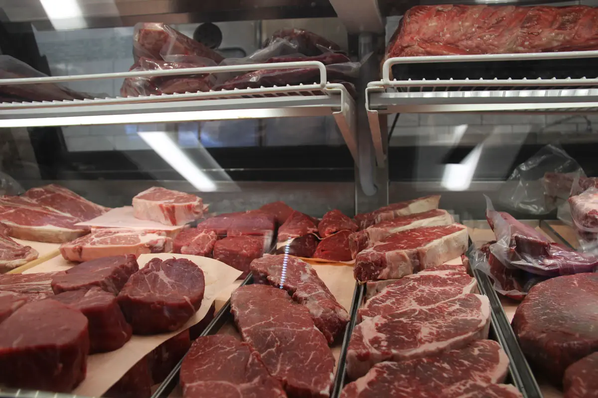 A butcher’s display case showcases an array of fresh, marbled beef cuts, neatly arranged at Tip Top Meats in Carlsbad. Photo by Jordan P. Ingram