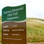 A sign for Veterans Memorial Trail in Carlsbad directs visitors toward the future site of Veterans Memorial Park. Photo by Cameron Adams