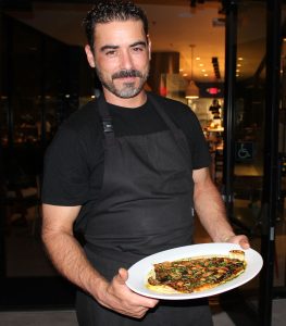 Executive Chef Juan Gonzalez presents Trucha Al Pil Pil whole ember roasted rainbow trout with pil pil sauce, garlic chips and fresh parsley. Photo by Rico Cassoni