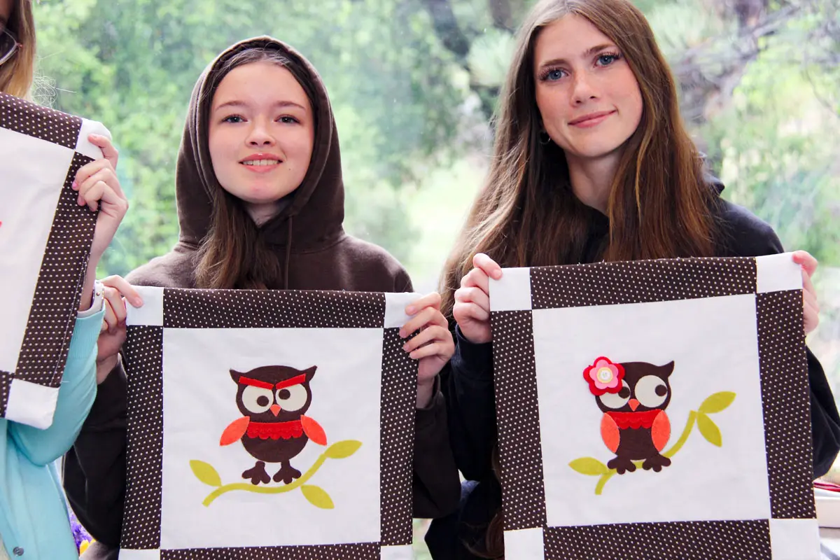 Julian Union High School sophomores Charlee Sparks and Lily Betts show off their quilting skills after learning from Eleanor Burns, a local master quilter. Photo by Samantha Nels