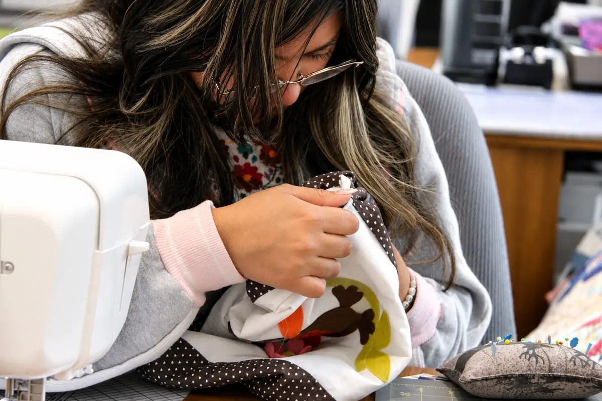 Michelle Cruz-Silva, a student at Julian Union High School, works on sewing quilt patterns together. Photo by Samantha Nelson