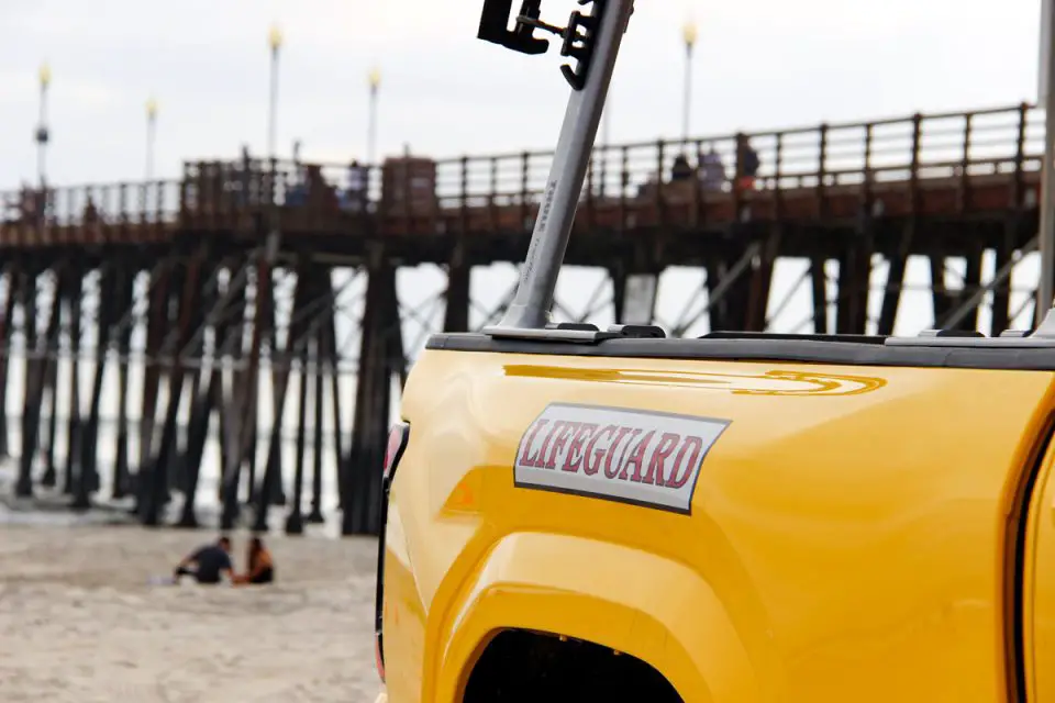 An Oceanside Lifeguard truck sits near the shoreline and pier. Photo by Samantha Nelson