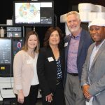 Vista Chamber of Commerce CEO Rachel Beld, left, joins Chamber board members Shannon Watkins, Roger Herzler and Zeke Corley beside robotic-assisted surgical technology on display during Tri-City Medical Center’s recent State of Tri-City event, which highlighted advances in minimally invasive spine care and surgical innovation in North County. Photo by Chris Kydd