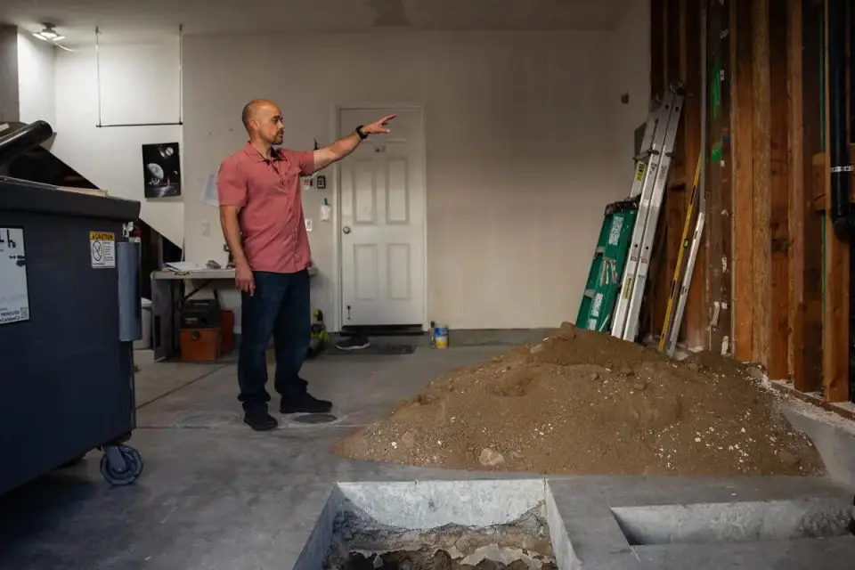 Adam Hardesty looks through the construction at his home in Carlsbad on Feb. 19, 2025. Hardesty wanted to convert the garage of his three-story condo into a ground-floor apartment despite opposition from his own Homeowners Association. Photo by Adriana Heldiz, CalMatters