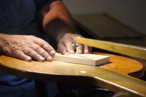 A view of hands working with a scroll saw.