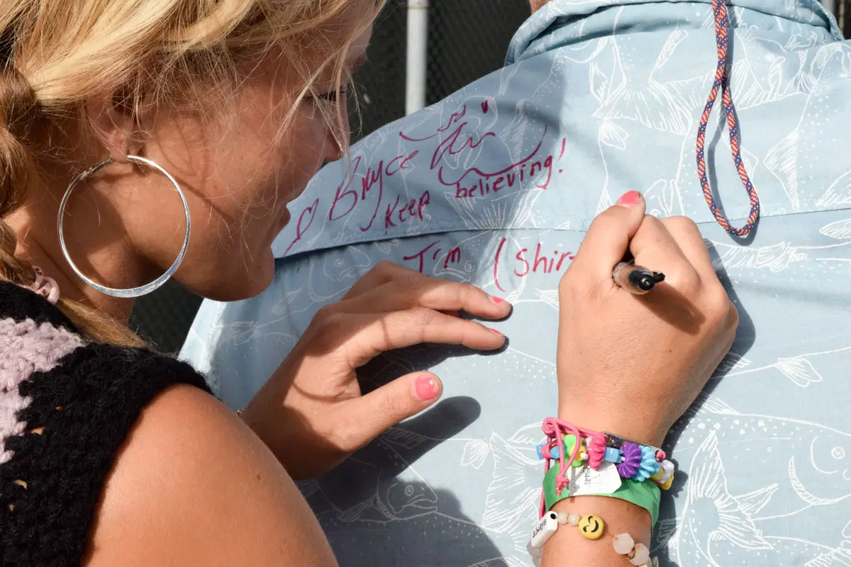 Two-time Olympian Bryce Wettstein writes personalized notes of encouragement for young fans during a community skate event this past weekend in Encinitas. Photo by Summer Hu
