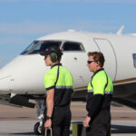 Ground crew members prepare for an arriving flight on the tarmac at McClellan-Palomar Airport in Carlsbad. File photo/Jordan P. Ingram